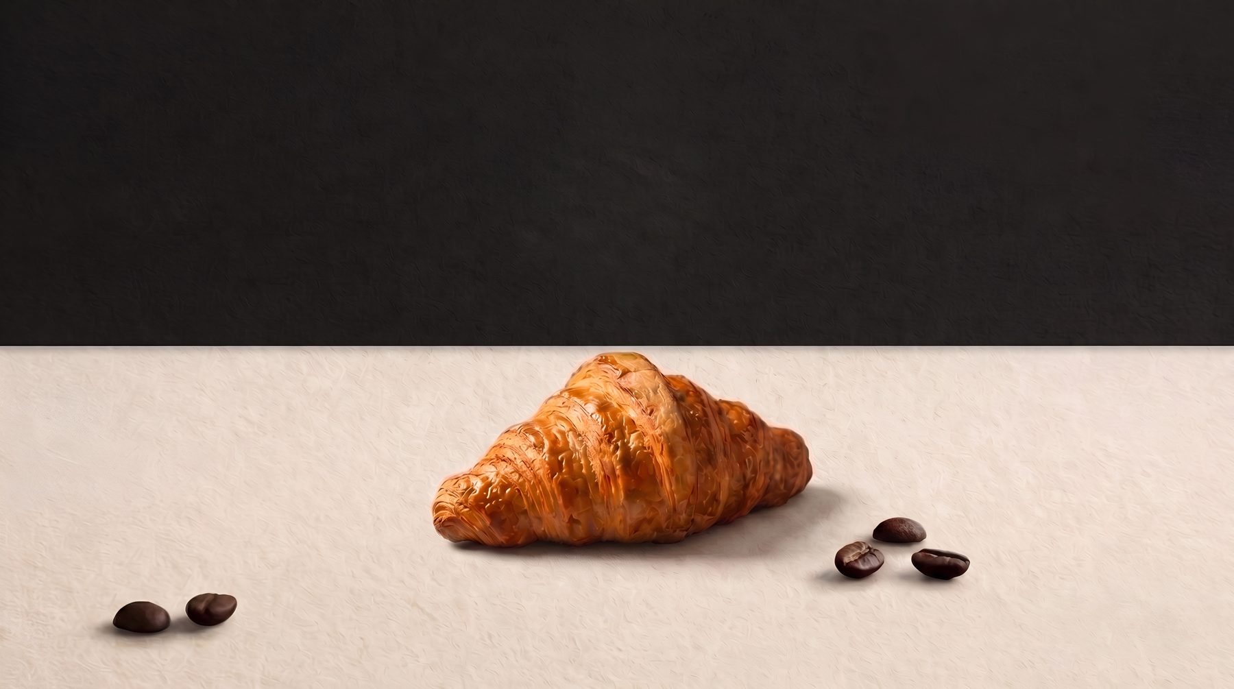 A butter croissant and coffee beans on a cream counter